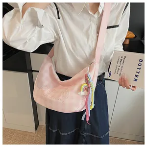 Détail du sac bandoulière demi-lune à carreaux roses avec broderie et gland arc-en-ciel