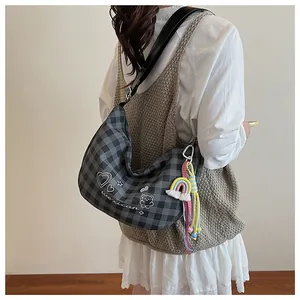 Détail du sac à bandoulière à carreaux avec griffonnages de cœurs et d'oursons