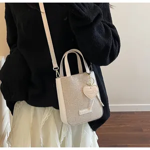 Detail of a beige leather mini handbag with TL CHICK logo and adjustable shoulder strap