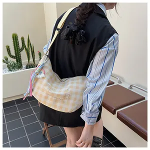 Détail du sac croissant à carreaux jaunes avec broderie ours et pompon arc-en-ciel