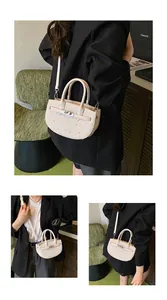 Detail of a beige saddle bag with silver rhinestones, featuring handle and shoulder strap