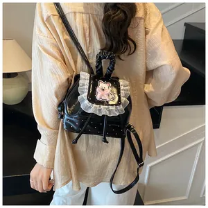 Close-up of black polka dot mini backpack with white lace edges and cute embroidery
