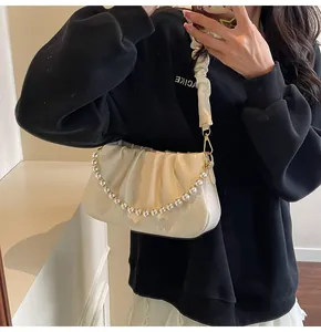 Detail der cremeweißen Ruched Cloud Tasche mit großer Perlenkette und Riemen