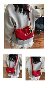 Macro detail of red canvas dumpling bag with white logo and striped drawstring zip