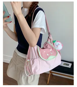 Detalle del bolso rosa con diseño de sandía, bordado Guava y un colgante de peluche