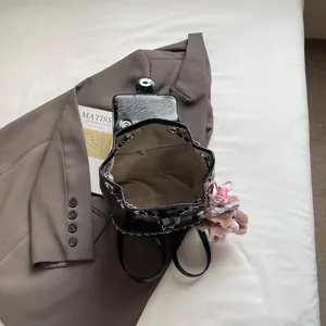 Schicker schwarzer Lackleder Rucksack mit Kettendetail und Plüschanhänger für Damen
