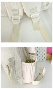 Détail d'un sac à dos blanc cassé montrant la boucle réglable et la poche latérale