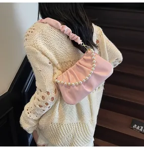 Detailansicht einer rosa gerafften Cloud-Tasche mit Perlengriff und weichem PU-Leder-Finish