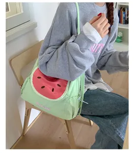 Primer plano del bolso de lona verde claro con gran estampado de sandía y bordado