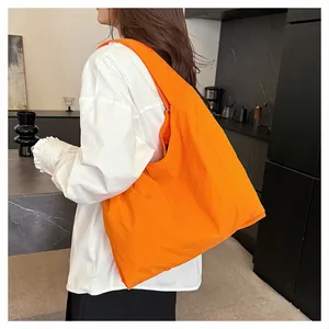 Detailed view of large orange tote bag with micro-wrinkle texture in a modern interior