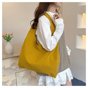 Detail of a ginger yellow oversized canvas tote bag with a minimalist integrated wide strap