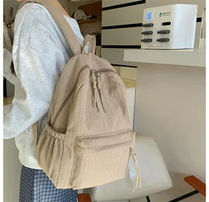 Détail d'un sac à dos beige minimaliste en tissu texturé avec cordons de fermeture éclair