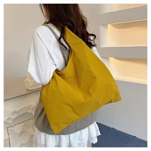 Model wearing a large ginger yellow canvas hobo bag, showing the spacious shoulder design