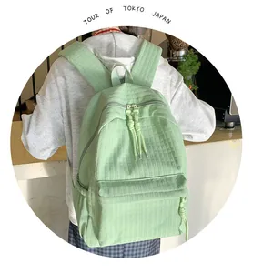 Détail d'un sac à dos vert menthe en tissu texturé avec fermeture éclair à double sens