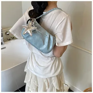 Dettaglio della borsa hobo a pieghe azzurra con ciondolo a stella argentata lucida