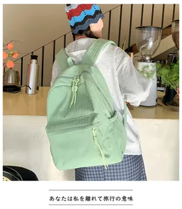 Vue détaillée du sac à dos en nylon vert menthe avec tirettes à nœuds et étiquette