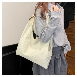Close-up of cream canvas tote bag with pleated texture shown on a model for daily use