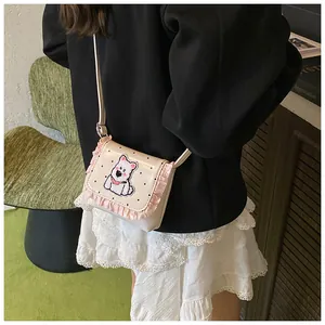 Detailed view of mini cream crossbody bag featuring pink ruffles and polka dot design