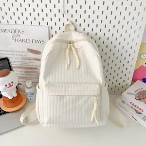 Détail du sac à dos en velours côtelé crème avec étiquette latérale et texture douce