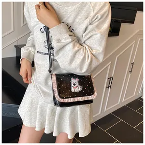 Close-up of cute black polka dot crossbody bag with pink ruffles and cartoon puppy patch
