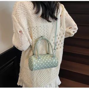 Detail of light green polka dot barrel bag with metal zipper and fine stitching