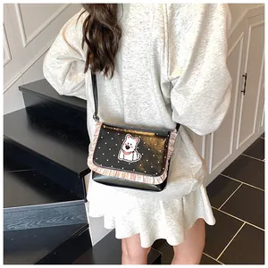 Detail of polka dot crossbody bag featuring pink ruffles and a cute puppy design on a model