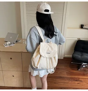 Detail of beige drawstring backpack with YOU JI BEAR logo in a casual setting