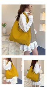 Detail of a large capacity bright yellow canvas tote bag with a minimalist shoulder strap