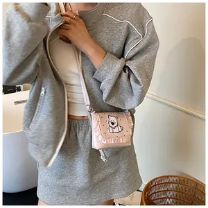 Detailed view of pink polka dot crossbody bag with ruffle trim and cute dog print