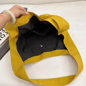 Large bright yellow crinkled nylon tote bag with spacious interior and zipper pocket