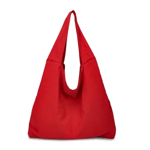 Minimalist red oversized canvas tote bag with pleated texture and wide shoulder strap