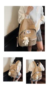 Detail of khaki nylon backpack with white woven tag and cute plush bear keychain