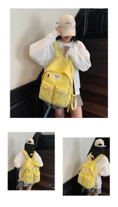Detail of a bright yellow nylon backpack featuring multiple pockets and a water-resistant texture