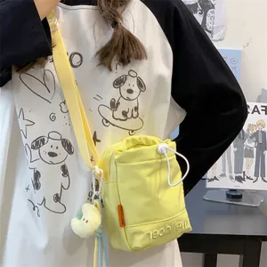 Gele nylon crossbody tas met trekkoord, sterren pluche hanger en borduursel