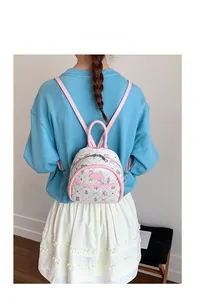 Rear view of model wearing a mini pink floral backpack with slim leather straps