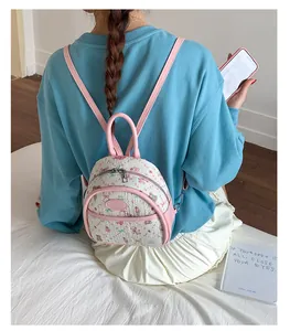 Close-up of a mini floral teddy bear backpack with pink straps on a person's back