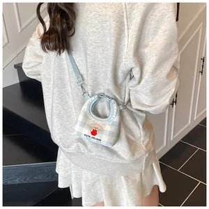 Dettaglio mini borsa a tracolla a scacchi blu con ricamo a cucciolo e pizzo