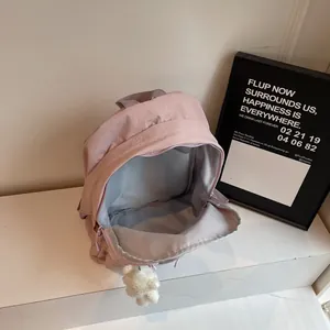 Pink nylon backpack with interior storage compartment and cute plush bear charm