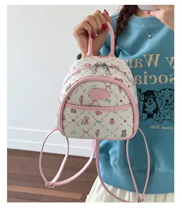 Detail of mini backpack showing cartoon bear patterns and pink leather handles