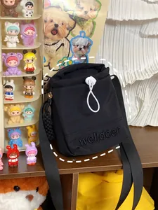 Detail van zwarte nylon crossbodytas met trekkoord en geborduurd logo voor dames