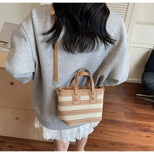 Detailaufnahme der gestreiften Strohtasche mit Fokus auf Webstruktur und Lederriemen