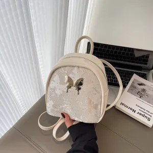 Mini mochila chic de mariposa en blanco crema con detalles metálicos plateados y correas finas