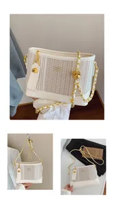 Détail du sac seau matelassé avec bandoulière chaîne dorée et charms mignons