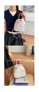 Mini fashion backpack with pink cartoon patterns and leather handles in a macro detail view