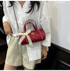 Détail du sac matelassé rouge avec nœud en dentelle et bandoulière sur modèle