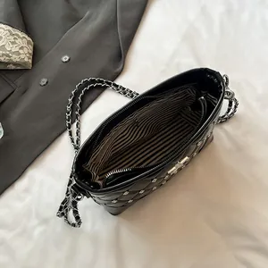 Quilted black leather shoulder bag with silver studs and striped lining interior view