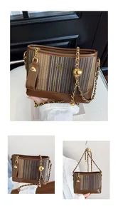 Détails du sac seau à rayures marron avec chaîne dorée et pendentifs boules dorées
