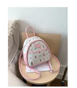 Detailed close-up of pink quilted mini backpack with cute teddy bear and strawberry patterns