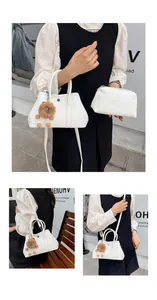 Detailansicht der weißen Tasche aus Narbenleder mit Löwenanhänger und kleiner Pouch