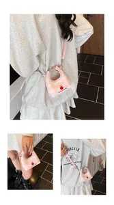 Dettaglio della mini borsa a quadretti rosa con bordo in pizzo e stampa di cucciolo